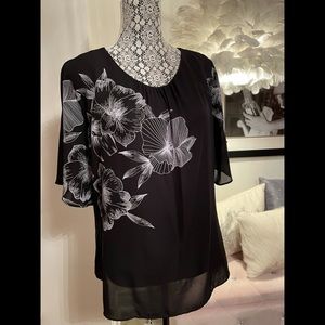 Elegant black blouse with white floral detail